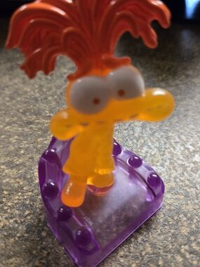 Translucent Orange Kids Character Figurine on Purple Base